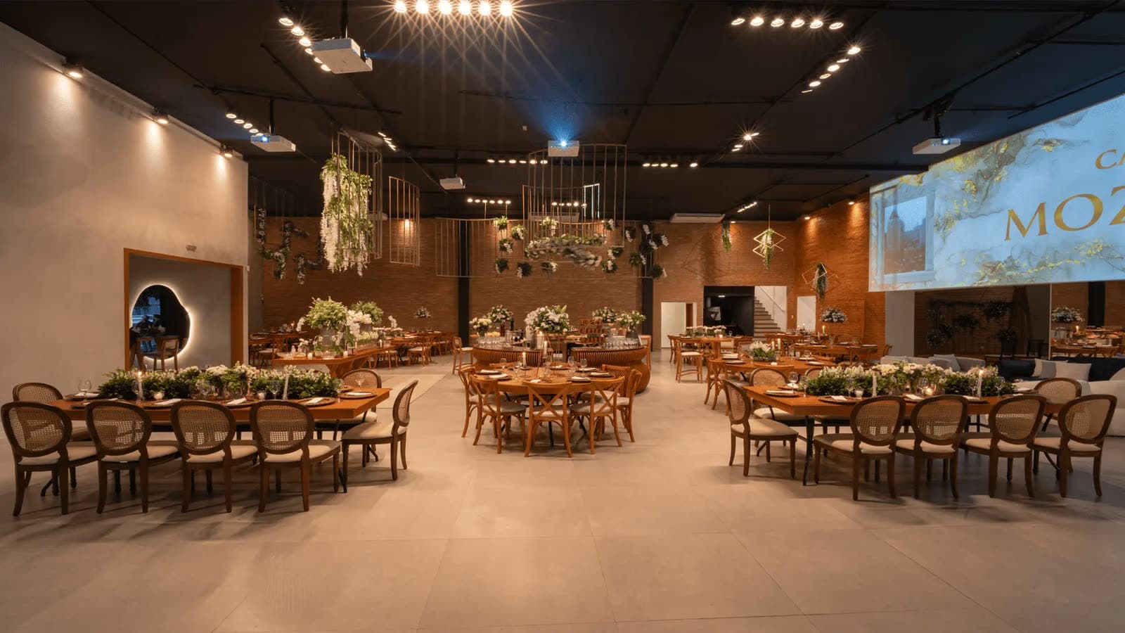 Salão da Casa Mozaik com mesas postas e decoração floral